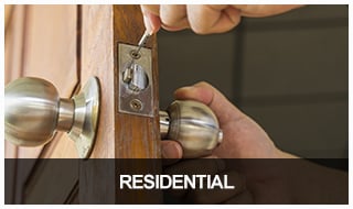 image of a locksmith repairing a front door lock on a home